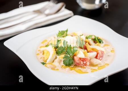 Salade de piyaz ou de haricots de style Antalya avec tahini et œuf sur une assiette en porcelaine blanche. Banque D'Images