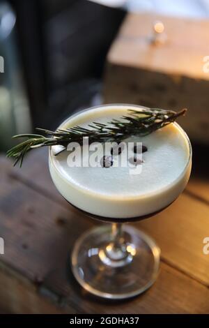 Cocktail au café avec grains de café et romarin sur fond de bois Banque D'Images