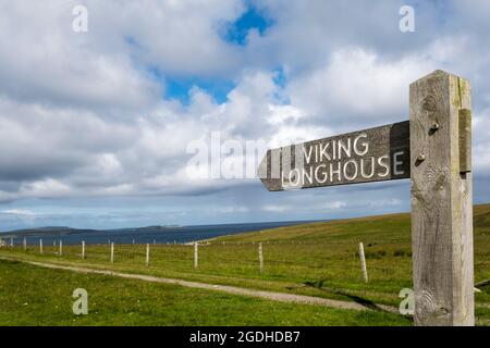 Panneau sur le site d'une longue maison viking excavée à Sandwick sur Unst, Shetland. Banque D'Images