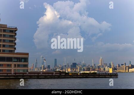 Des nuages d'été flottent au-dessus du gratte-ciel Midtown Manhattan dans le quartier de Manhattan depuis Jersey City NJ le 9 juin à New York City NY USA. Banque D'Images