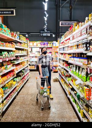 Les jeunes femmes indiennes, hommes et autres personnes, magasinent pour de la nourriture dans l'allée bondée d'un supermarché hypermarché tout en portant des masques pendant la COVID Banque D'Images