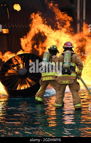 Les pompiers affectés au 628e Escadron de génie civil travaillent ensemble pour déclencher un incendie lors d'un exercice de brûlage en direct le 30 mars 2021 à la base commune de Charleston, S.C. les spécialistes de la protection incendie participent à cet exercice tous les trois mois pour renouveler leur préparation à l'entraînement. Le site de formation est le seul site disponible avec des capacités de simulation d'incendie d'avion sur JB Charleston. (É.-U. Photo de la Force aérienne par Airman 1er classe Jade Dubiel) Banque D'Images