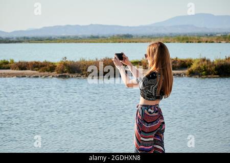 Une jeune touriste prend des photos de salins avec son téléphone Banque D'Images