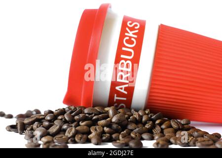 Chernihiv, Ukraine - 14 janvier 2020 : grains de café et tasse Starbucks sur fond blanc Banque D'Images