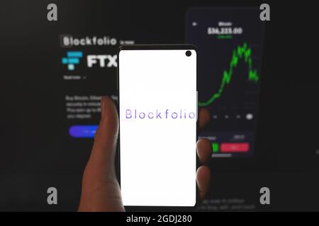 Logo Blockfolio sur le smartphone en main avec arrière-plan flou du site Web. Bourse de crypto-monnaies, plateforme de suivi de portefeuille de crypto. Swansea, Royaume-Uni - 31 juillet 2021 Banque D'Images