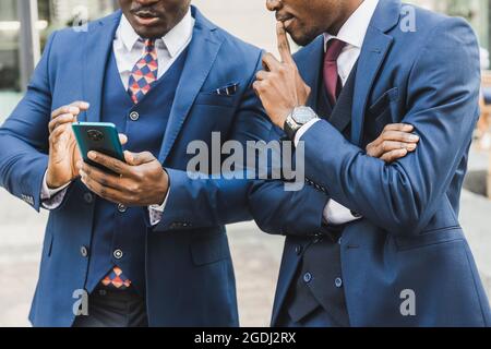 Rencontre de deux partenaires hommes d'affaires afro-américains noirs en costumes et en lunettes à l'extérieur Banque D'Images