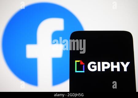 Dans cette illustration, un logo Giphy apparaît sur l'écran d'un smartphone avec un logo Facebook en arrière-plan. Banque D'Images