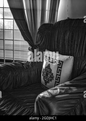 ISLAMABAD, PAKISTAN - 22 juillet 2021 : une photo verticale monochromatique d'un coussin élégant et d'un canapé à Islamabad, Pakistan. Banque D'Images