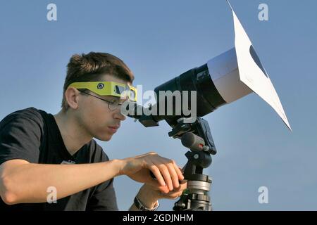 Homme observant une éclipse solaire avec un télescope, Autriche Banque D'Images