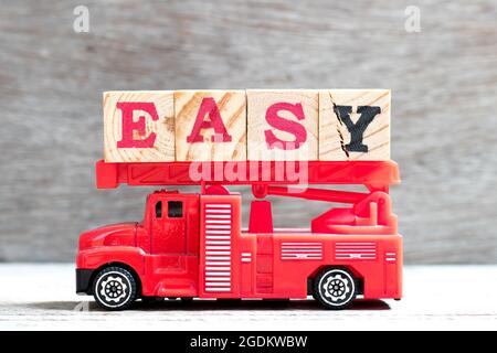 Jouet feu échelle camion tenir le bloc de lettres dans le mot facile sur fond de bois Banque D'Images