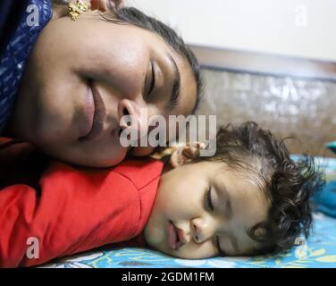 portrait en gros plan de la mère indienne dormant avec son bébé. Banque D'Images