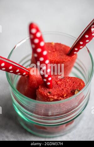 Dessert d'été avec des pop-suits de pastèque bio servis sur l'assiette avec de la glace et du romarin Banque D'Images