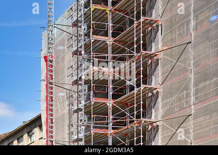 Partie du chantier de construction avec échafaudage sur la façade de bâtiment de plusieurs étages pendant la rénovation Banque D'Images