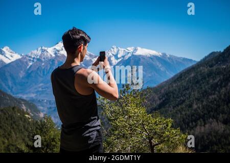 Jeune homme taking photo with cell phone Banque D'Images