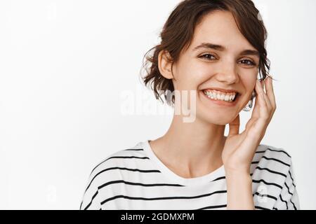 Portrait en gros plan de belle femme brunette souriant dents blanches, visage touchante, peau du visage claire et lumineuse, cosmétologie et femmes beauté concept Banque D'Images