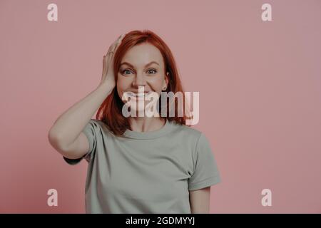 Portrait d'excitée tête rouge Ginger fille touchant la tête avec l'expression du visage surprise Banque D'Images