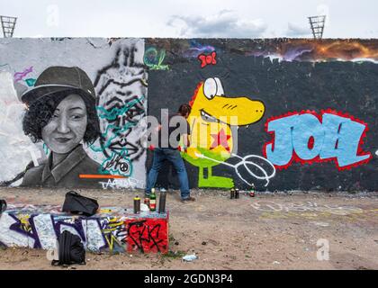 Un jeune artiste peint de nouveaux œuvres d'art sur mur à Mauerpark, Prenzlauer Berg, Berlin Banque D'Images