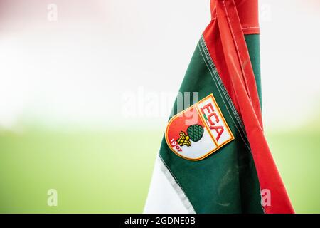 Augsbourg, Allemagne. 14 août 2021. Football: Bundesliga, FC Augsburg - TSG 1899 Hoffenheim, premier jour du match à la WWK Arena. Le logo du club du FC Augsbourg, blason avec l'inscription FCA et l'image d'une noix de pin, peut être vu sur un drapeau d'angle dans le stade. Crédit : Matthias balk/dpa - REMARQUE IMPORTANTE : Conformément aux règlements de la DFL Deutsche Fußball Liga et/ou de la DFB Deutscher Fußball-Bund, il est interdit d'utiliser ou d'avoir utilisé des photos prises dans le stade et/ou du match sous forme de séquences et/ou de séries de photos de type vidéo./dpa/Alay Live News Banque D'Images