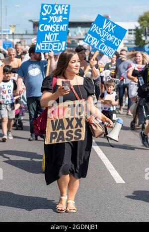 Southend on Sea, Essex, Royaume-Uni. 14 août 2021. Un certain nombre d'événements du rassemblement pour la liberté ont lieu dans le monde entier pour protester contre les passeports du vaccin COVID et les plans de vaccination des enfants. L'un d'eux est une marche de démonstration à Southend on Sea, avec des manifestants tenant des pancartes et des messages de chants alors qu'ils marchaient autour des attractions de la ville en bord de mer et bloquait les routes. Une femme caucasienne a mené la marche de protestation avec le mégaphone et le non au passeport vaccinal (raccourci) message sur la plaque Banque D'Images