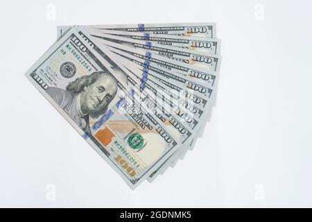 Pile de billets de cent dollars répartis sur fond blanc, isoler Banque D'Images