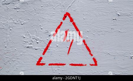 Panneau de danger électrique rouge avec foudre dans un triangle sur une boîte de jonction en métal peinte en gris Banque D'Images