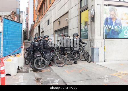 Un groupe de policiers anti-émeute avec des VTT attendent dans une ruelle à BLM et la marche de protestation anti Trump à Seattle, aux États-Unis Banque D'Images