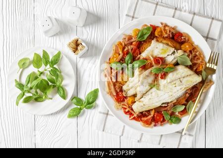 Acqua Pazza, poisson poché italien dans une sauce à base de tomate et de vin blanc avec fenouil, herbes et pain crostini croustillant sur une assiette blanche, plat Banque D'Images