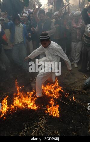 Un garçon musulman saute sur une effigie brûlante tout en protestant à l'extérieur de l'historique Jama Masjid à Delhi contre l'attaque des États-Unis d'Amérique (USA) Banque D'Images