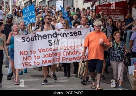 Southend on Sea, Essex, Royaume-Uni. 14 août 2021. Un certain nombre d'événements du rassemblement pour la liberté ont lieu dans le monde entier pour protester contre les passeports du vaccin COVID et les plans de vaccination des enfants. L'une de ces manifestations est une marche de démonstration à Southend on Sea, avec des manifestants tenant des pancartes et des messages de chants alors qu'ils marchaient autour des attractions de la ville en bord de mer et bloquait les routes. Les manifestants défilent devant les boutiques touristiques du bord de mer, avec des personnes âgées en voyage d'une journée Banque D'Images