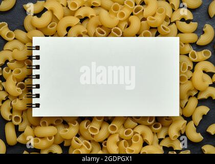 Ouvrir un cahier vide sur Macaroni Pasta Background, Copy Space for Text, Food Background concept. Banque D'Images