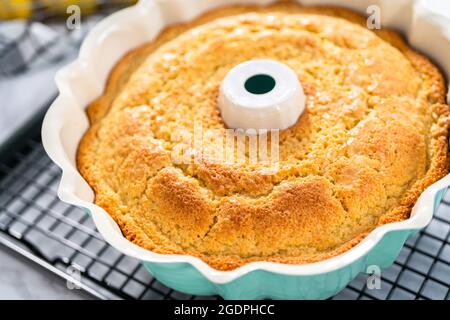 Refroidissement fraîchement cuit un gâteau de livre de citron sur un panier de cuisine froid. Banque D'Images