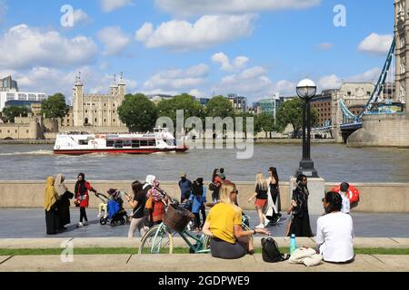 Touristes sur la promenade de la Reine, au bord de la Tamise en face de la Tour de Londres, un jour d'été, Southwark, Royaume-Uni Banque D'Images