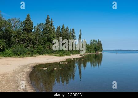 Le rivage du lac Clear avec des reflets dans le parc national du Mont-Riding, Manitoba, Canada. Banque D'Images