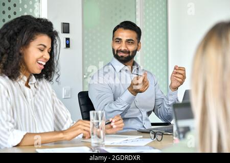 Souriant des directeurs afro-américains et indiens discutant du projet lors d'une réunion de bureau. Banque D'Images