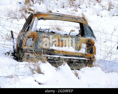 Une scène hivernale d'une voiture volée, abandonnée et brûlée dans un endroit de beauté populaire dans le Brisbane Glen, près de Largs dans Ayrshire, en Écosse Banque D'Images