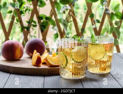 Mocktail d'été ou thé glacé à base de pêche, de lime et de menthe Banque D'Images