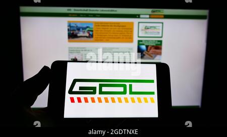 Personne tenant un smartphone avec le logo de l'Union Gewerkschaft Deutscher Lokomotivfuehrer (GDL) à l'écran devant le site Web. Mise au point sur l'affichage du téléphone. Banque D'Images