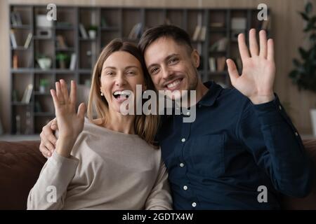 Accueil de couple en famille commence la visioconférence sur le canapé Banque D'Images