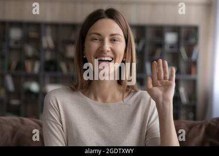 Femme souriante regardant l'appareil photo salutation ami commencer un appel vidéo Banque D'Images