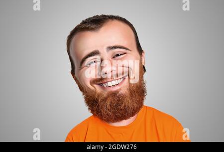 Portrait en caricature avec une grande tête d'un homme barbu et joyeux aux cheveux rouges. Rire, personne joyeuse Banque D'Images