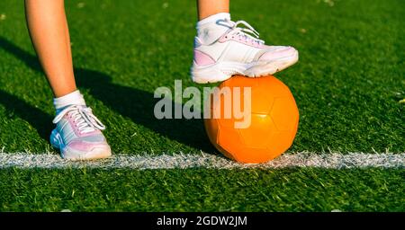 Fille joueur de football. Gros plan sur le pied de la jeune fille sur le ballon pour le jeu. Banque D'Images