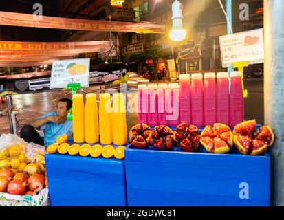 Vendeur de rue vendant des fruits et des jus à la cabine éclairée, dans la nuit, Yaowarat Rd, Chinatown, Bangkok, Thaïlande Banque D'Images