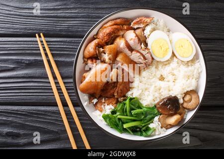 Authentique recette thaï pour le porc braisé pied kao kha moo gros plan dans le bol sur la table. Vue horizontale du dessus Banque D'Images