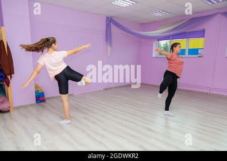 Fille instructeur de danse montre les éléments du nombre à une autre fille. Entraînement de danse. Banque D'Images