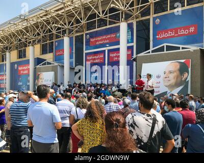 Le Caire, Égypte - août 14 2021 : les citoyens égyptiens à l'exposition attendent leur tour pour recevoir le vaccin Covid-19 coronavirus, avec deux des organisateurs et l'arrière-plan du président égyptien Banque D'Images