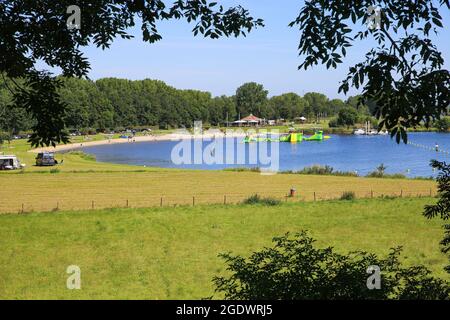 Roermond (Noorderplas), pays-Bas - juillet 9. 2021: Vue sur le lac idyllique de baignade avec forêt et plage de sable contre ciel bleu d'été Banque D'Images