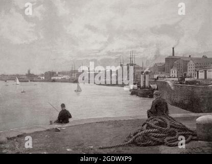 A la fin du XIXe siècle, un jeune garçon pêchant dans la rivière Shannon à bord d'un bateau à aubes amarré le long des quais de Limerick, en Irlande Banque D'Images