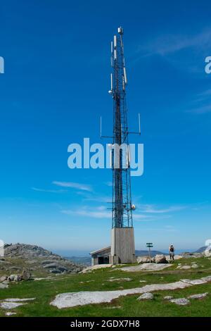 Randonneur à côté de la tour cellulaire de téléphone mobile au-dessus des montagnes rurales en Europe (Norvège), avec fjords en arrière-plan Banque D'Images