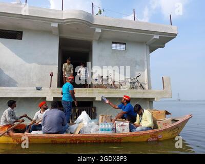 Prayagraj, Inde. 14 août 2021. Les travailleurs du Parti Samajwadi fournissent du matériel de secours (nourriture) aux victimes des inondations dans le district de Prayagraj, Uttar Pradesh. Ganga et Yamuna au-dessus de la marque de danger, les gens sont confrontés à des difficultés pour obtenir de la nourriture et de l'eau potable. (Photo de Shashi Sharma/Pacific Press) Credit: Pacific Press Media production Corp./Alay Live News Banque D'Images