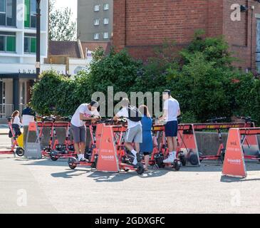 08-12-2021 Portsmouth, Hampshire, Royaume-Uni UN groupe d'adolescents sur un site de stationnement de VOI Scooter qui embauche des e-trottinettes Banque D'Images